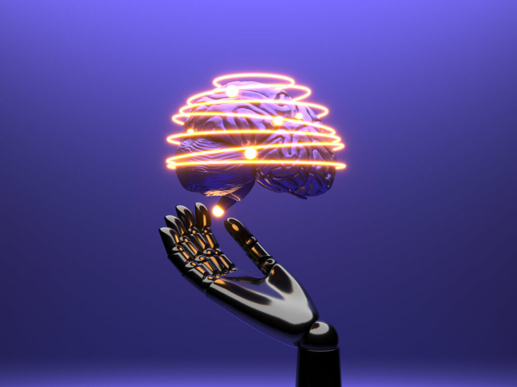 Imagem ilustrativa de uma mão robótica encostando em um cérebro iluminado representando inteligência artificial