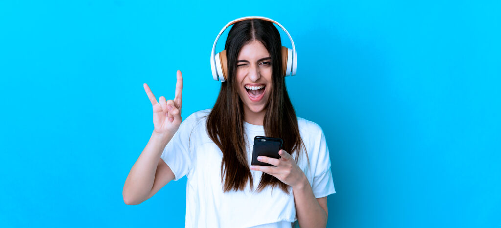 Una chica en el celular con audiófonos para captar clientes